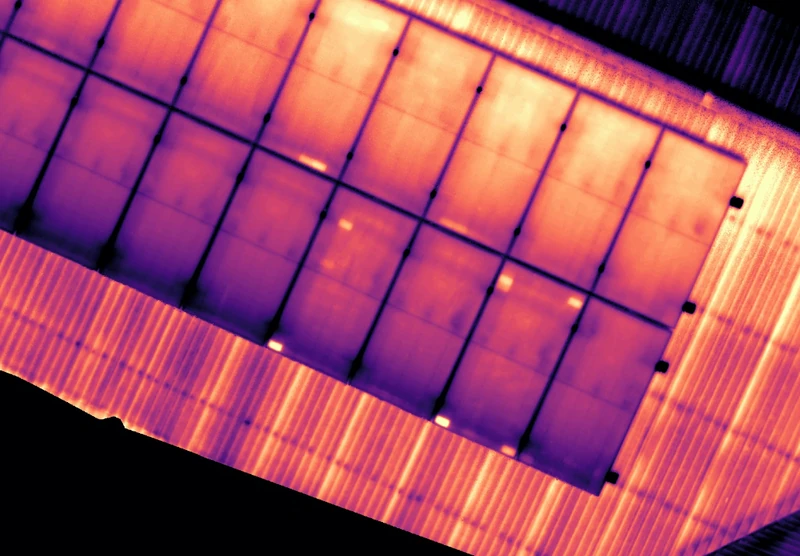 Instalacja fotowoltaiczna i fragment dachu w opracowaniu termowizyjnym.